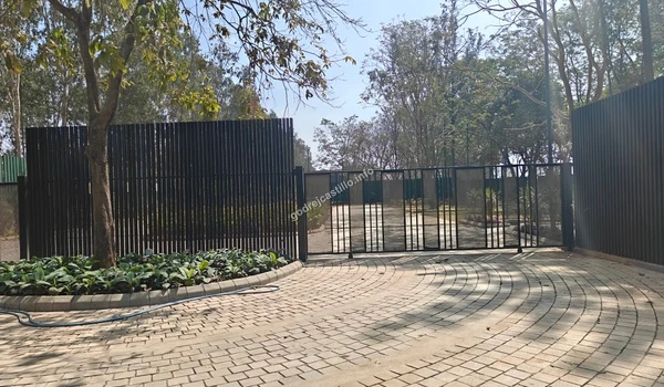 The high-quality architectural entry at Godrej Castillo featuring stone-paved internal roadways surrounded by scenic nature and mature trees