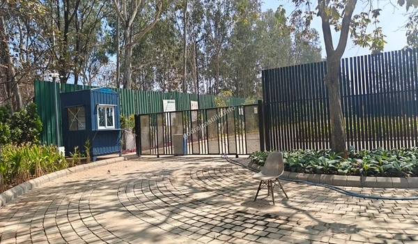A smooth stone-paved elite entryway near the main gate of Godrej Castillo bordered by professional landscaping and designer street lamps