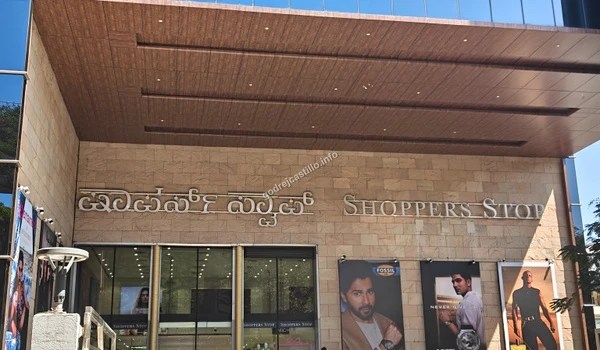 Broad street level shot of the Shoppers Stop multi-brand retail entrance surrounded by large lifestyle ad banners close to Godrej Castillo
