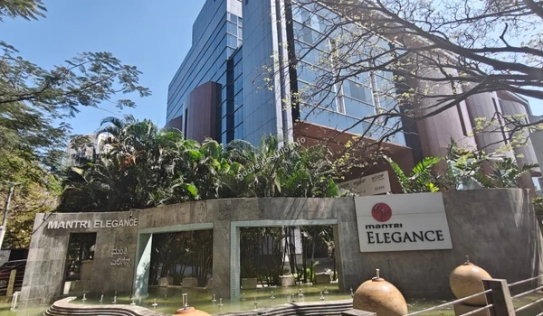 Entrance to the Mantri Elegance retail and commercial space featuring water fountains and manicured greenery, a short distance from Godrej Castillo.