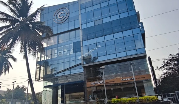 Street view of a contemporary glass-facade building with a Starbucks outlet, enhancing the modern neighborhood lifestyle of Godrej Castillo