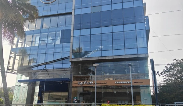 Sleek multi-story commercial complex housing a Tata Alliance Starbucks cafe, serving as a perfect hangout spot for Godrej Castillo residents