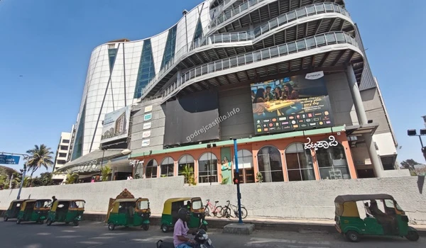 Wide street perspective of the Nexus Vega City mall entrance showing its expansive layout and modern aesthetics near the Godrej Castillo community.