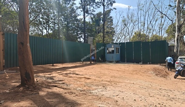 A detailed look at the modern black slat perimeter fencing and the vibrant green lawn at the Godrej Castillo project site