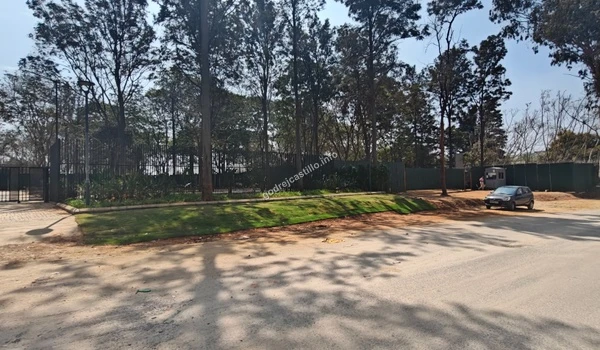 Exterior view of the Godrej Castillo project site showing the secure boundary wall and planned green belts