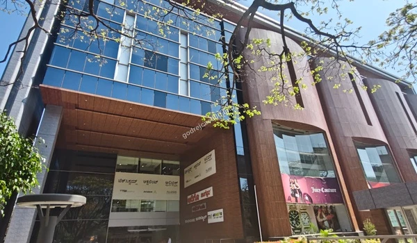 A broad view of the premium retail and office complex featuring tall glass panels and high-end fashion outlets close to Godrej Castillo.