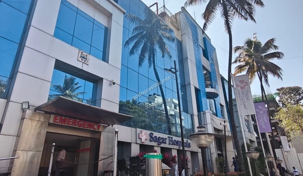 Modern blue glass facade of Sagar Hospitals providing comprehensive healthcare solutions for Godrej Castillo residents.
