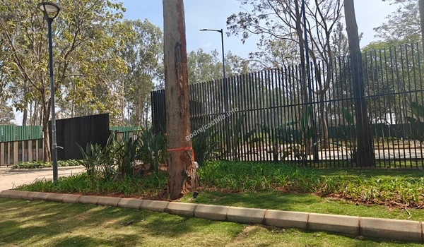 The secure green construction hoarding marking the boundary of the Godrej Castillo project site during the development phase