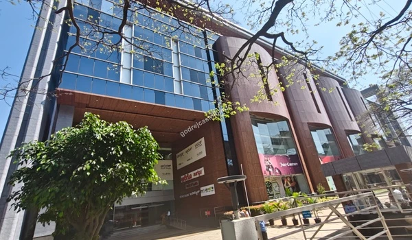 Modern commercial building facade showcasing the Juicy Couture outlet and other premium brands, offering upscale retail experiences near Godrej Castillo.