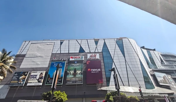 Upward angle view of the modern architecture at Nexus Vega City shopping center, providing premium retail options for Godrej Castillo residents.